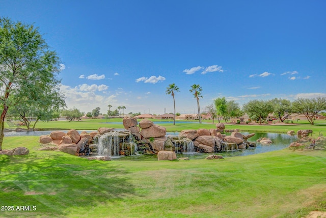 surrounding community with a lawn and a water view