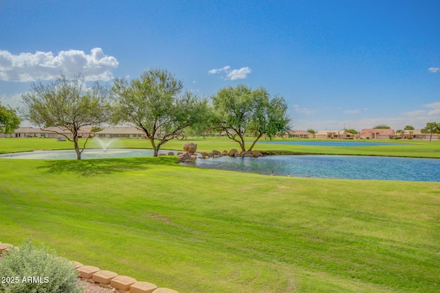 view of property's community with a water view and a yard