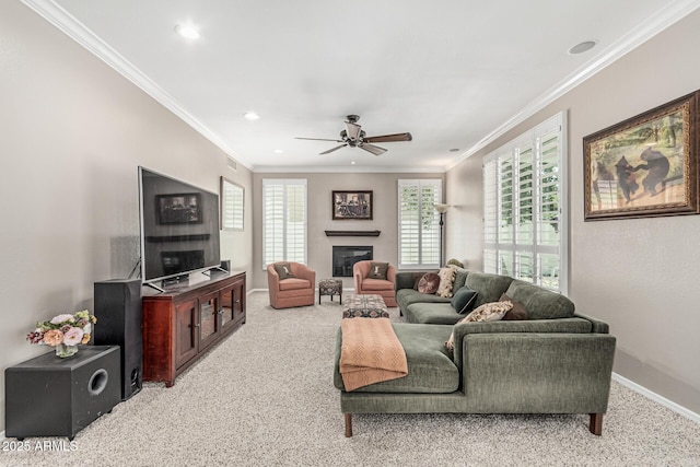 living room featuring carpet floors, ornamental molding, baseboards, and ceiling fan