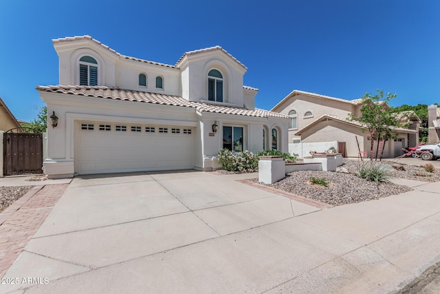 mediterranean / spanish-style house featuring a tile roof, concrete driveway, and stucco siding