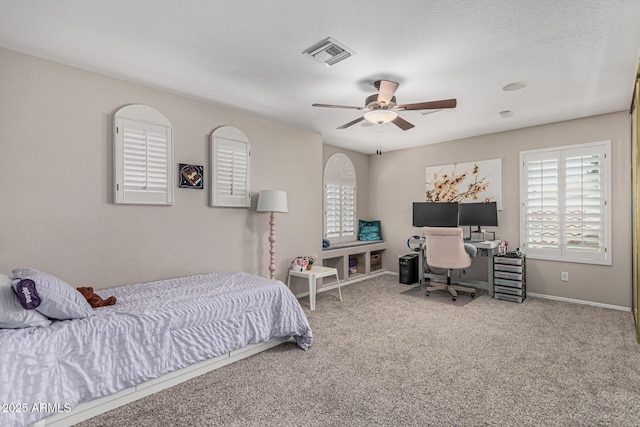 carpeted bedroom featuring baseboards, a ceiling fan, and visible vents