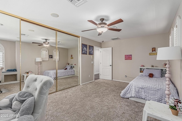 carpeted bedroom featuring a closet, visible vents, a ceiling fan, and baseboards