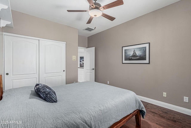 bedroom featuring wood finished floors, visible vents, a ceiling fan, a closet, and baseboards