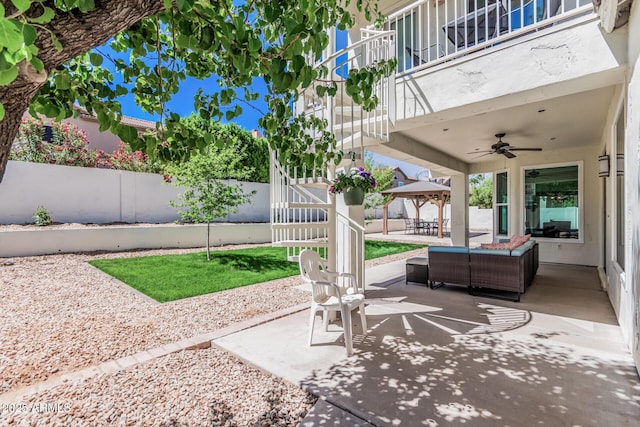 view of patio / terrace featuring a fenced backyard, a gazebo, an outdoor living space, and ceiling fan