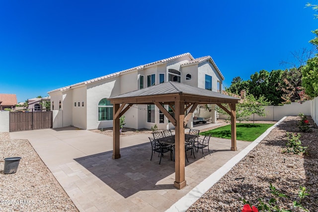 view of patio / terrace featuring a gazebo, a fenced backyard, and a gate