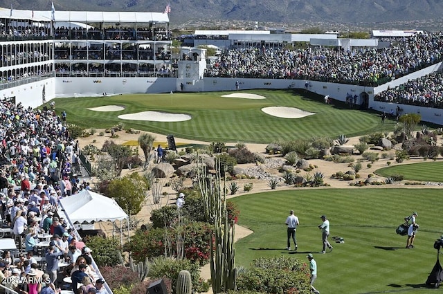 view of community featuring a yard and view of golf course