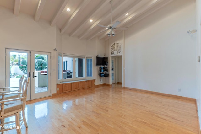 unfurnished living room featuring a ceiling fan, baseboards, high vaulted ceiling, beam ceiling, and light wood-style flooring