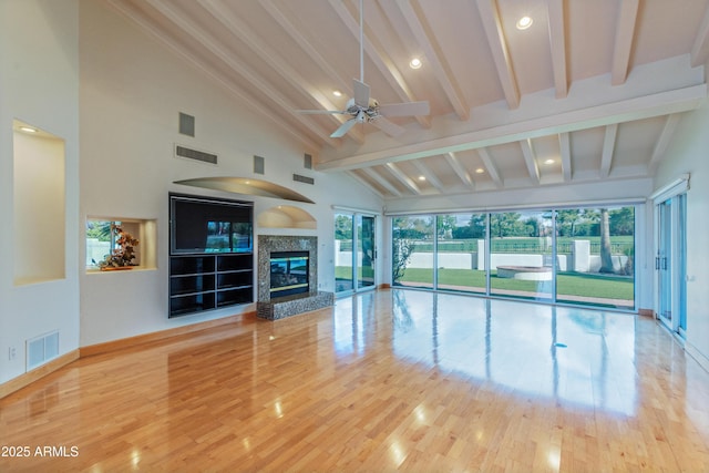 unfurnished living room with wood finished floors, visible vents, and high vaulted ceiling