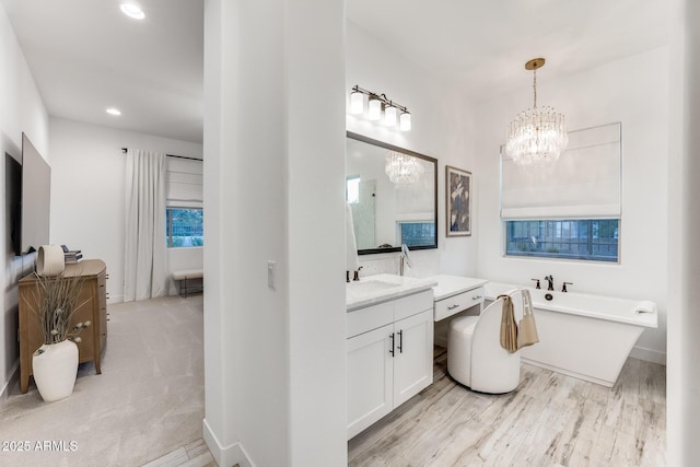 5901 E Sierra Morena St, Mesa, AZ 85215 - bathroom with a freestanding tub, a chandelier, wood finished floors, and vanity
