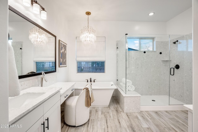 5901 E Sierra Morena St, Mesa, AZ 85215 - bathroom with a freestanding bath, a shower stall, wood finished floors, and a notable chandelier
