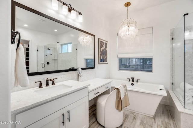 5901 E Sierra Morena St, Mesa, AZ 85215 - full bathroom with vanity, a chandelier, a shower stall, wood finished floors, and a soaking tub