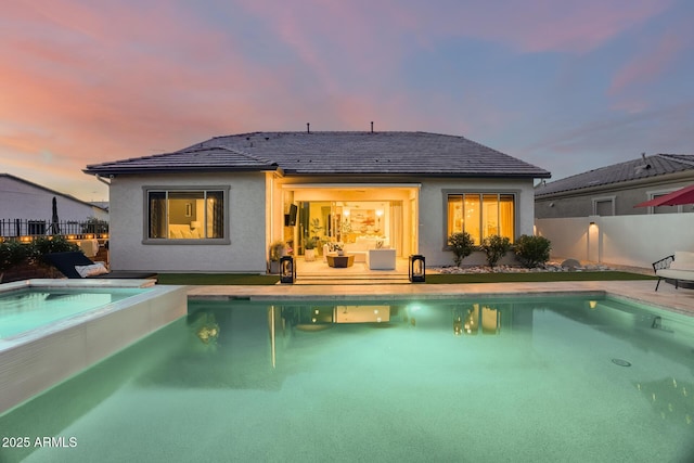 5901 E Sierra Morena St, Mesa, AZ 85215 - back of property at dusk featuring stucco siding, an in ground hot tub, fence, and a fenced in pool