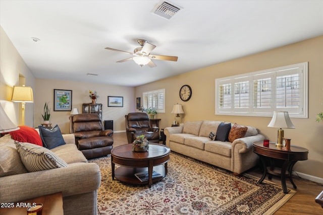 living room featuring visible vents, baseboards, wood finished floors, and ceiling fan