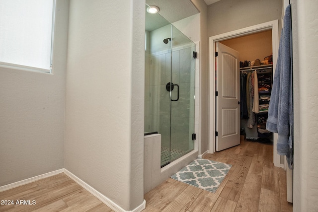 bathroom with hardwood / wood-style floors and walk in shower