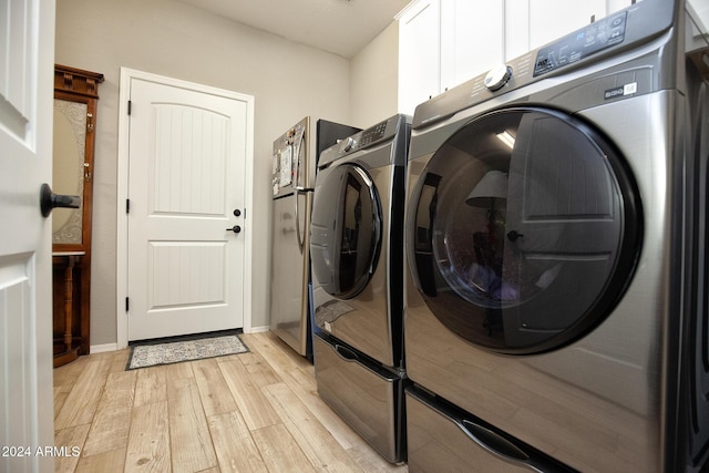 laundry room with cabinets, separate washer and dryer, and light hardwood / wood-style flooring