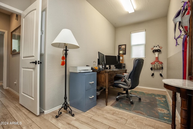 office space with light hardwood / wood-style floors and a textured ceiling