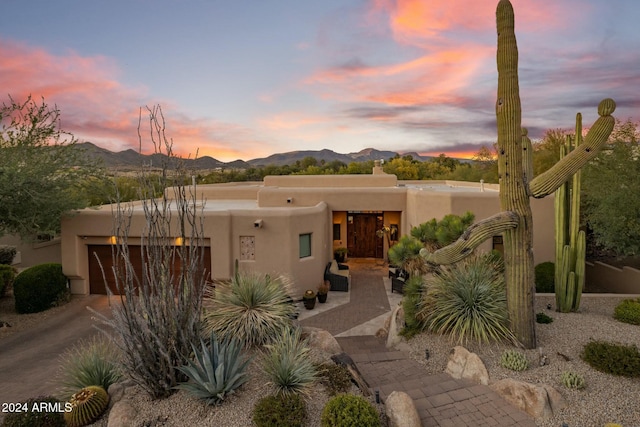 pueblo-style house featuring a mountain view and a garage