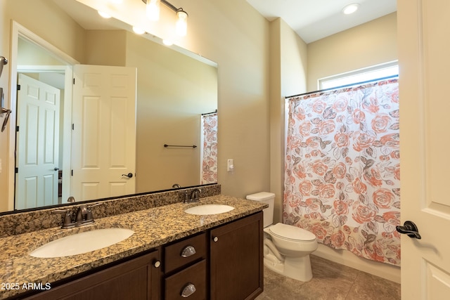 bathroom featuring tile patterned flooring, a sink, toilet, and double vanity