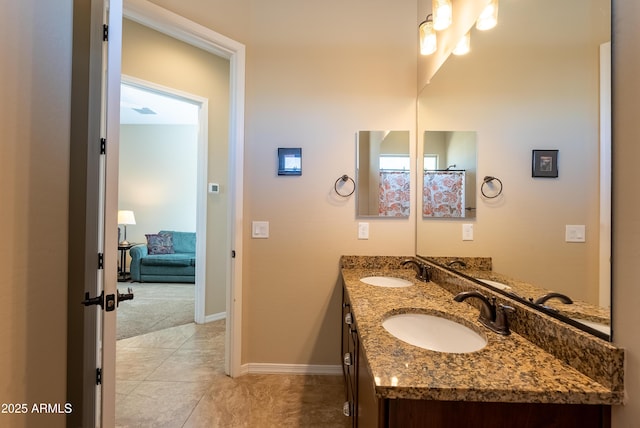 bathroom featuring double vanity, baseboards, a sink, and tile patterned floors