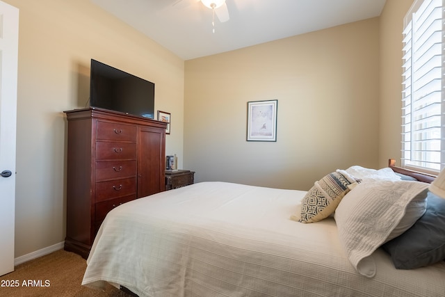 bedroom featuring light carpet, baseboards, and a ceiling fan