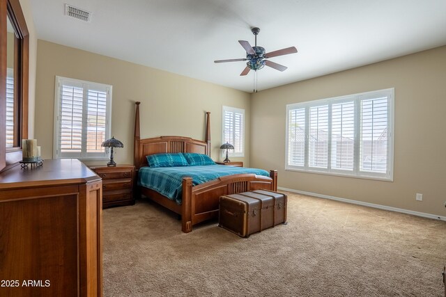 bedroom with baseboards, multiple windows, visible vents, and light colored carpet