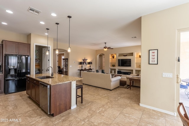 kitchen featuring visible vents, arched walkways, dishwasher, black refrigerator with ice dispenser, and a sink