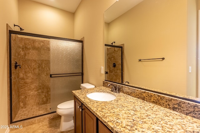 bathroom with vanity, a shower stall, and toilet