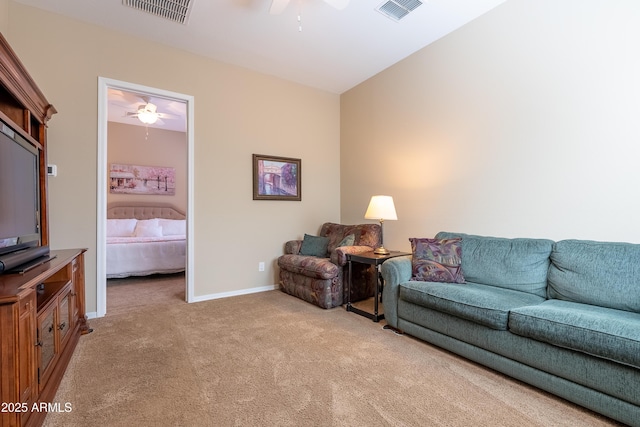 living area featuring baseboards, visible vents, a ceiling fan, and light colored carpet