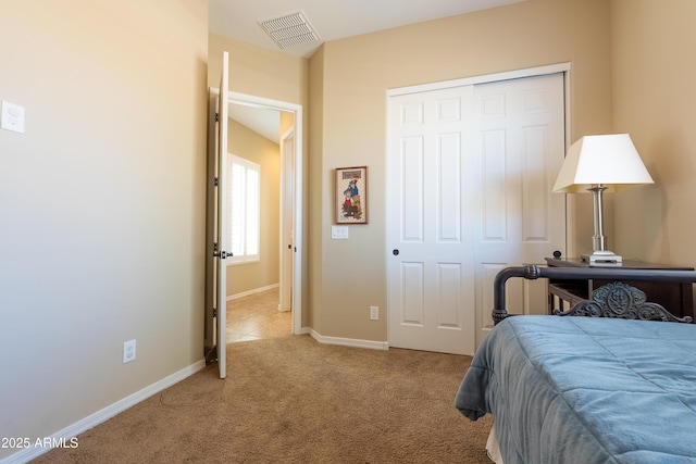 carpeted bedroom featuring a closet, visible vents, and baseboards