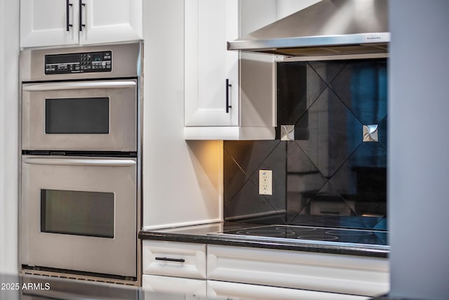 kitchen featuring double oven, black electric cooktop, white cabinets, and exhaust hood