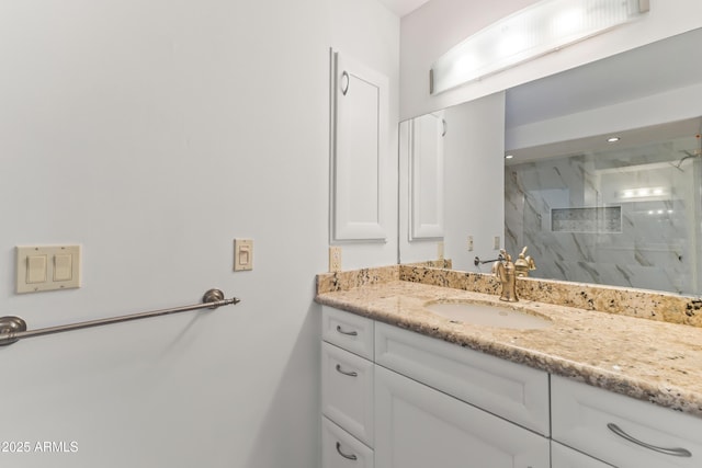 bathroom with a marble finish shower and vanity