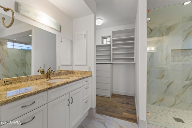 bathroom featuring marble finish floor, plenty of natural light, vanity, and a marble finish shower