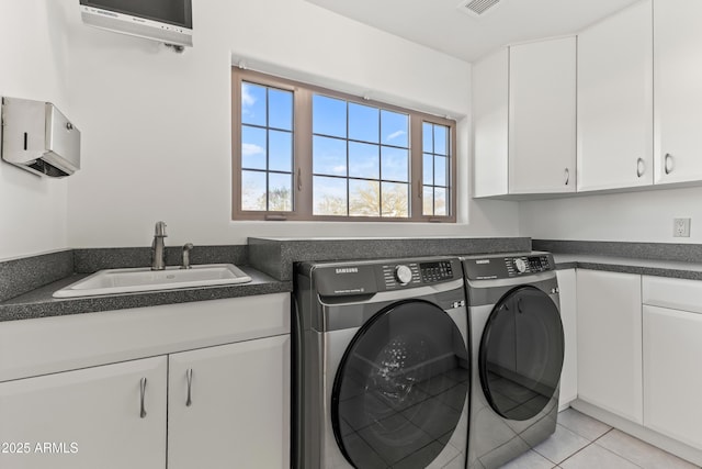 laundry room featuring a wall unit AC, cabinet space, light tile patterned flooring, a sink, and separate washer and dryer