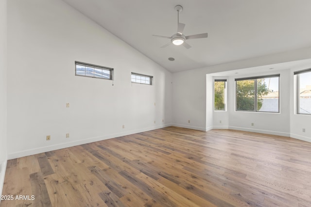 spare room with a ceiling fan, light wood-type flooring, high vaulted ceiling, and baseboards