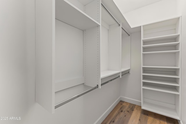 walk in closet with wood finished floors