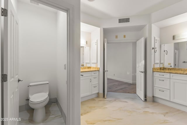 bathroom featuring toilet, marble finish floor, visible vents, and vanity