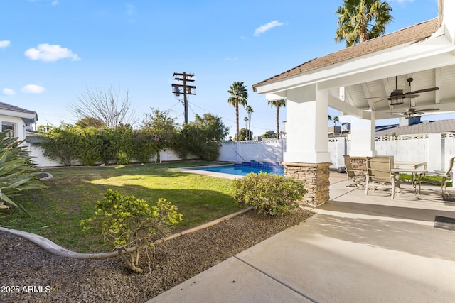 view of yard featuring ceiling fan, a fenced backyard, a fenced in pool, outdoor dining space, and a patio area