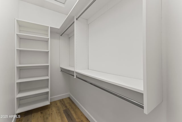 walk in closet with wood finished floors