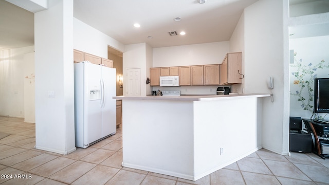 kitchen featuring kitchen peninsula, light brown cabinetry, white appliances, and light tile patterned floors