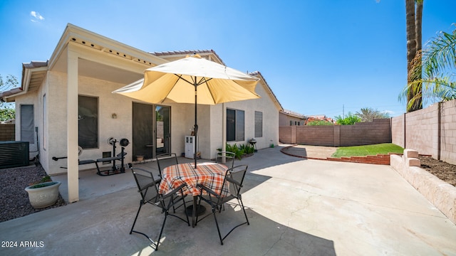 rear view of property with cooling unit and a patio