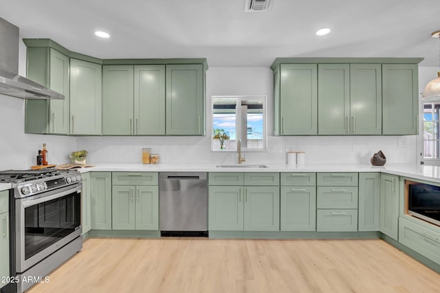 2712 N 20th Dr, Phoenix, AZ 85009 - kitchen featuring green cabinets, stainless steel appliances, wall chimney exhaust hood, and recessed lighting