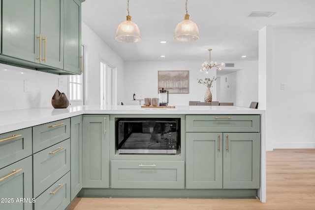 2712 N 20th Dr, Phoenix, AZ 85009 - kitchen featuring green cabinetry, black microwave, decorative light fixtures, light countertops, and recessed lighting