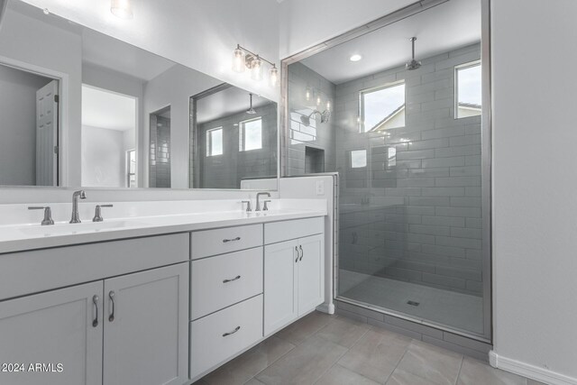 bathroom featuring dual vanity, walk in shower, and tile patterned floors