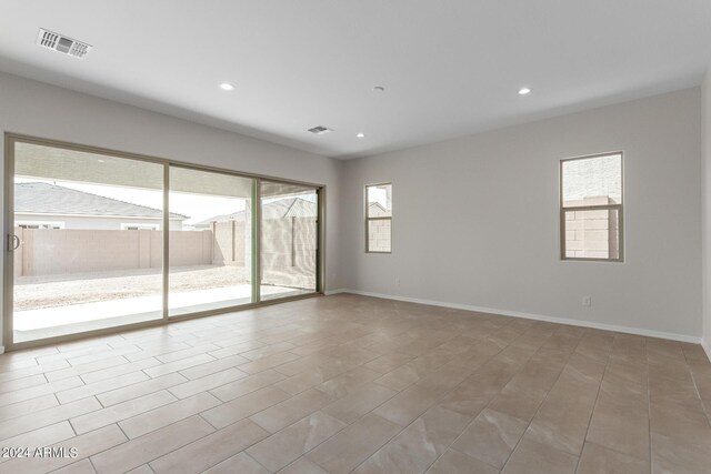 spare room featuring a wealth of natural light and tile patterned floors