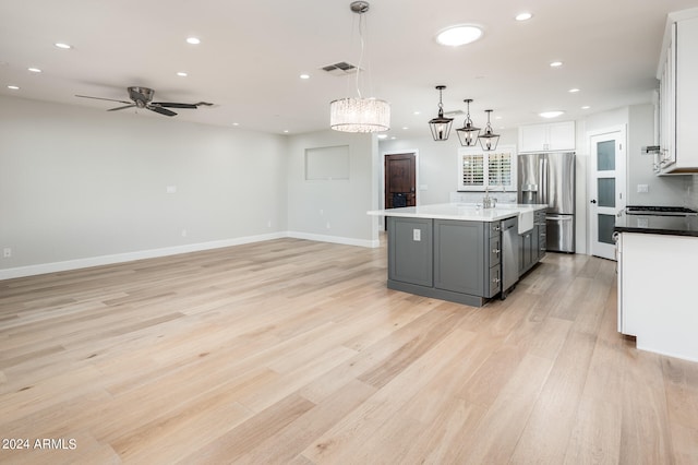 kitchen featuring pendant lighting, an island with sink, gray cabinetry, stainless steel fridge with ice dispenser, and white cabinetry