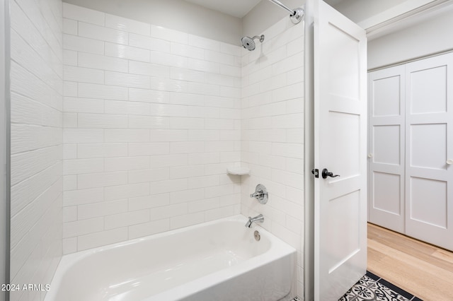 bathroom featuring wood-type flooring and tiled shower / bath