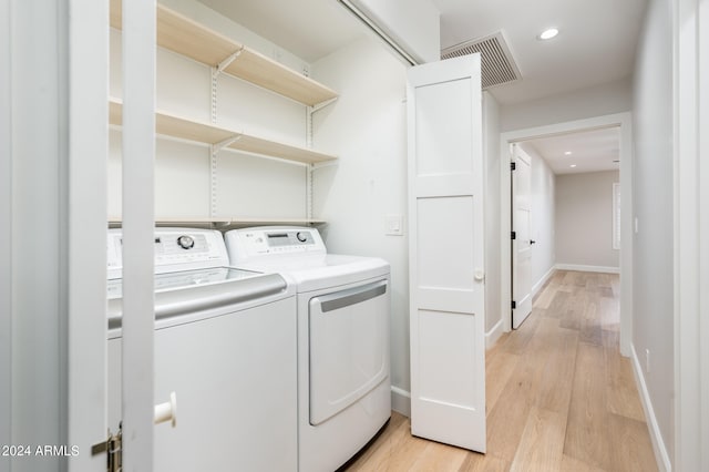 washroom with light wood-type flooring and independent washer and dryer