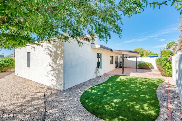 rear view of house featuring a lawn and a patio area