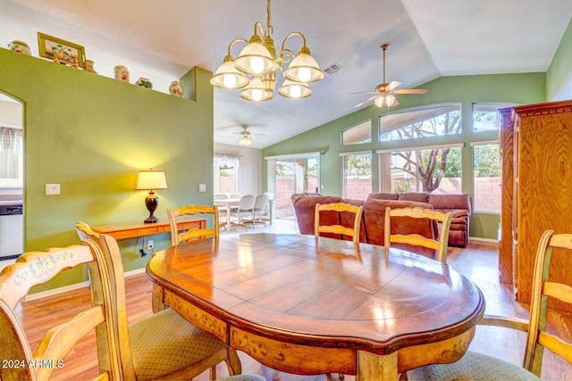 dining room with light wood finished floors, lofted ceiling, visible vents, baseboards, and ceiling fan with notable chandelier