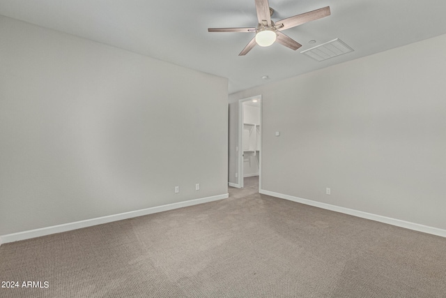 carpeted spare room featuring ceiling fan